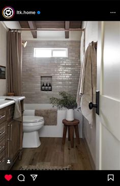 a white toilet sitting in a bathroom next to a wooden cabinet and counter with a potted plant on it