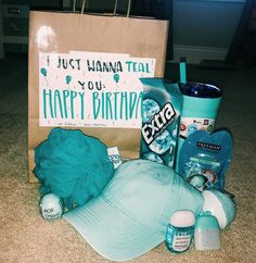 a birthday gift bag with personal care items in it and a hat on the floor