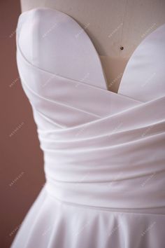 the back of a white wedding dress on a mannequin