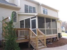 a house with screened porch and stairs leading up to the front door