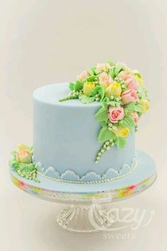 there is a blue cake with flowers on it