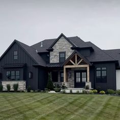 a large black house with lots of windows on the front and side of it's roof