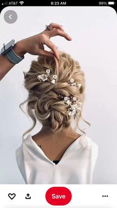 a woman's hair is braided into a low bun with flowers in it