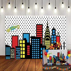 a birthday party with balloons, cake and batman wall mural in a room decorated with polka dots