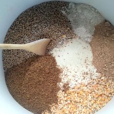 a white bowl filled with dry ingredients and a wooden spoon