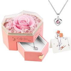 an open pink box with a rose in it next to a necklace and card holder