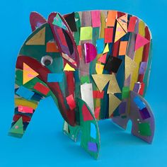 an elephant made out of colored paper on a blue background