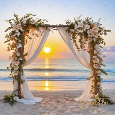 an outdoor wedding set up on the beach with white flowers and greenery at sunset