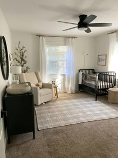 a baby's room with a crib, chair, and couch in it