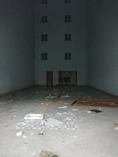 an empty room with broken glass on the floor and trash scattered all over the floor