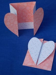 two folded paper hearts sitting next to each other