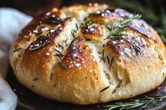 a loaf of bread with rosemary sprigs on top