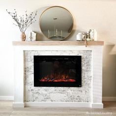 a white fireplace with a mirror on the top and fire in the middle, next to it