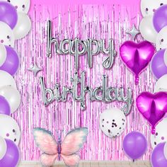 a pink and white birthday party with balloons, confetti, and butterfly decorations