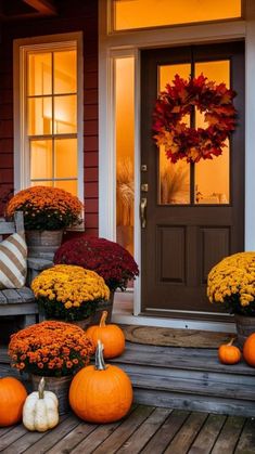 pumpkins and gourds are sitting on the porch