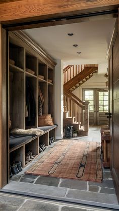 an entry way with a rug and some shoes on the floor in front of it