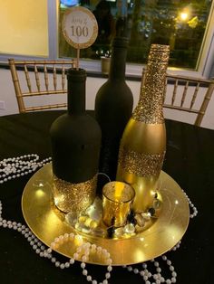 two champagne bottles are sitting on a gold plate