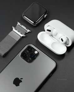 an apple watch, headphones and earbuds are on the table next to each other