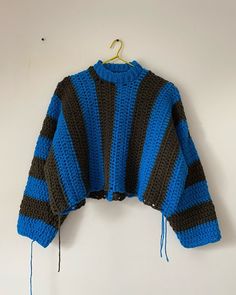 a blue and black sweater hanging on a wall