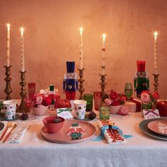 the table is set for christmas dinner with candles