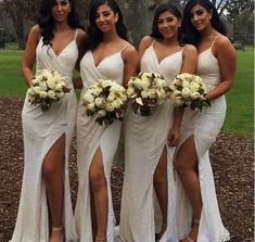 the bridesmaids are all dressed in white dresses and holding their bouquets together