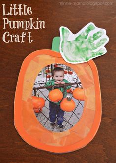 a little pumpkin craft with an orange and green paper cutout on the front, and a hand print in the middle