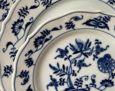 three blue and white plates sitting on top of each other