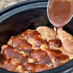 the sauce is being poured over the meat in the slow cooker