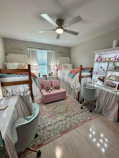 a bedroom with bunk beds, desks and chairs in the middle of the room