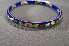 I am offering this fabulous vintage enameled bracelets. This piece is truly gorgeous, and it has the following features: * beautiful vintage bangle * floral design * multi colored * cloissonne * stackable * 2.5 inches in diameter This is a fantastic and classic piece. There is tons of sparkle and shine with this piece. It will beautifully complement your upcoming fashion season. Buyer pays all shipping and handling. Vintage Blue Enamel Bracelets, Blue Enamel Bangle Gift, Blue Enamel Bangle As A Gift, Blue Enamel Bangle Perfect As A Gift, Blue Enamel Bangle Bracelets, Vintage Multicolor Enamel Bangle, Handmade Enamel Bangle, Vintage Round Enamel Bangle, Blue Enamel Bangle Bracelet