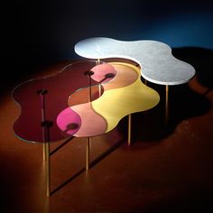 three tables with different colors and shapes on them