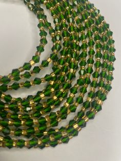 Single Strand Waist Bead Hermankono – a captivating accessory meticulously handcrafted with emerald green crystal glass seed beads and adorned with opulent gold glass seed bead accents. This waist bead is a celebration of sophistication and allure, embodying the spirit of Hermankono. 💚 Emerald Green Crystal Glass Seed Beads - Timeless Elegance: Hermankono features a luxurious array of emerald green crystal glass seed beads, imparting an air of timeless elegance. The deep, rich hue of emerald green symbolizes renewal and prosperity, making this waist bead a statement of both style and significance. 🌟 Gold Glass Seed Bead Accents - Opulent Brilliance: Adorning Hermankono are opulent gold glass seed bead accents, adding a touch of regal brilliance. Gold has long been associated with wealth Green Waist Beads, Emerald Green Crystal, Beaded Fashion, Waist Jewelry, Strong Hand, Jewerly Beads, Waist Beads, Green Crystal, Green Tones