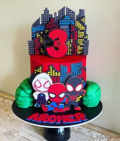 a three tiered cake decorated with spiderman and hulk