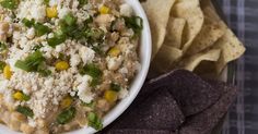 a white bowl filled with rice and corn next to tortilla chips