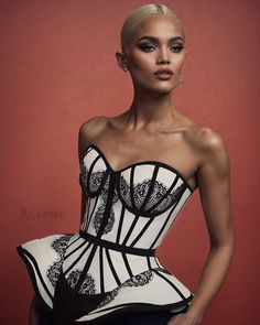 a woman in a white and black corset posing for the camera with her hands on her hips