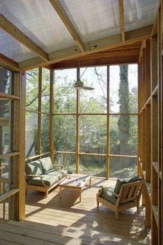 the inside of a house with wooden floors and large windows that look out onto trees