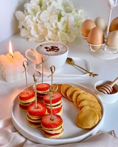 a plate topped with lots of food next to a bowl of eggs and some utensils