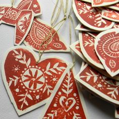 red and white heart shaped tags hanging from strings on a table with string attached to them