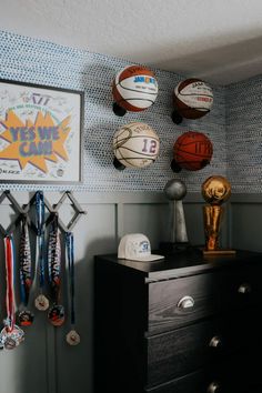 there are many basketballs hanging on the wall in this boys's sports room