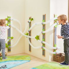 two children playing with toys in a playroom