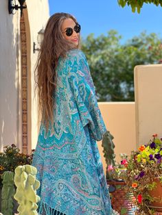 Our Tempting Turquoise Paisley Kimono Coat is the pop of colour you need in your wardrobe! This bright kimono coat practically glows with it's beaming intense colour. Pax Philomena is located in Arizona which is known for its turquoise which is also one of Jean Marie's favourite stones! Throw on your favourite turquoise jewelry with this kimono coat and be the brightest in the room! You are sure to make everyone around you smile! The use of boiled wool for clothing dates back multiple millennia Hippie Style Blue Kimono For Spring, Blue Outerwear With Kimono Sleeves For Spring, Multicolor Bohemian Outerwear With Paisley Print, Bohemian Multicolor Paisley Print Outerwear, Bohemian Spring Outerwear With Paisley Print, Blue Kimono Sleeve Outerwear For Vacation, Blue Outerwear With Kimono Sleeves For Vacation, Bohemian Outerwear With Paisley Print For Spring, Turquoise Long Sleeve Outerwear For Spring