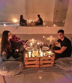 two people are sitting on the floor with candles