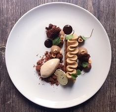 a white plate topped with food on top of a wooden table