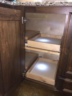 an open cabinet with drawers in a kitchen