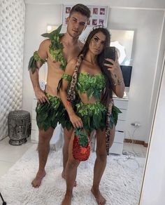 a man and woman in leafy costumes taking a selfie