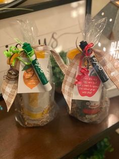 two small jars filled with different types of items on top of a wooden table next to each other