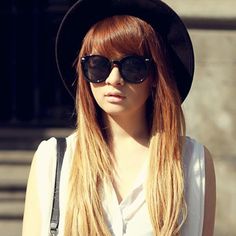 a woman with long hair wearing sunglasses and a hat