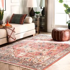 a living room filled with furniture and a rug on top of a hard wood floor