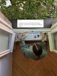 a person standing in front of an oven holding a tennis racquet and looking up at the ceiling