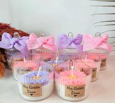 small candles with pink and purple bows on them